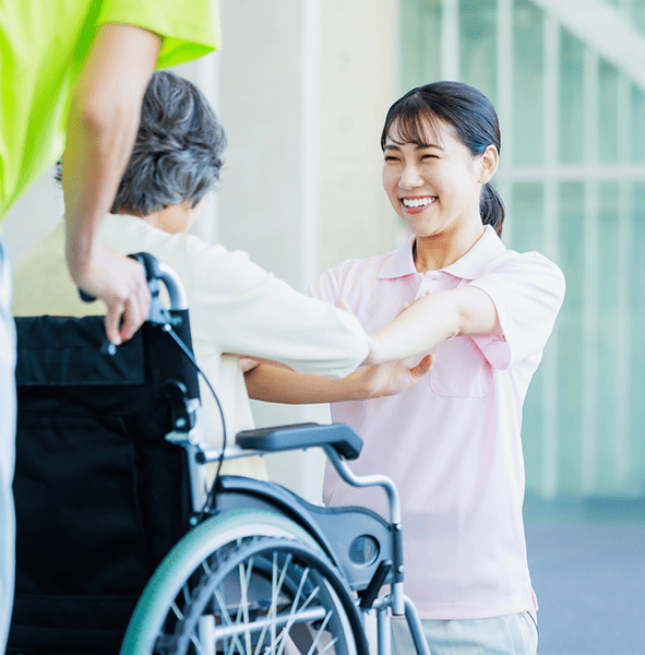 写真：車椅子を押す介護士