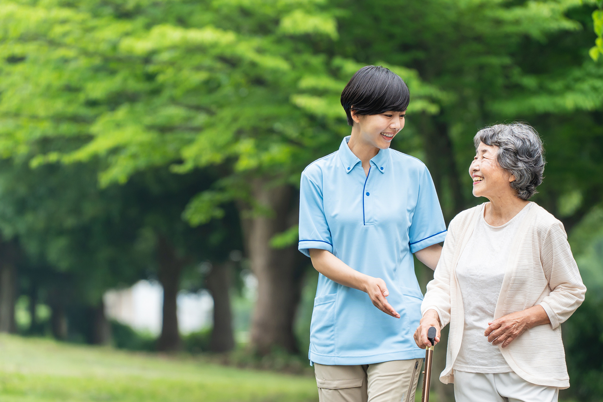 写真：介護士と手を繋ぐ利用者さん